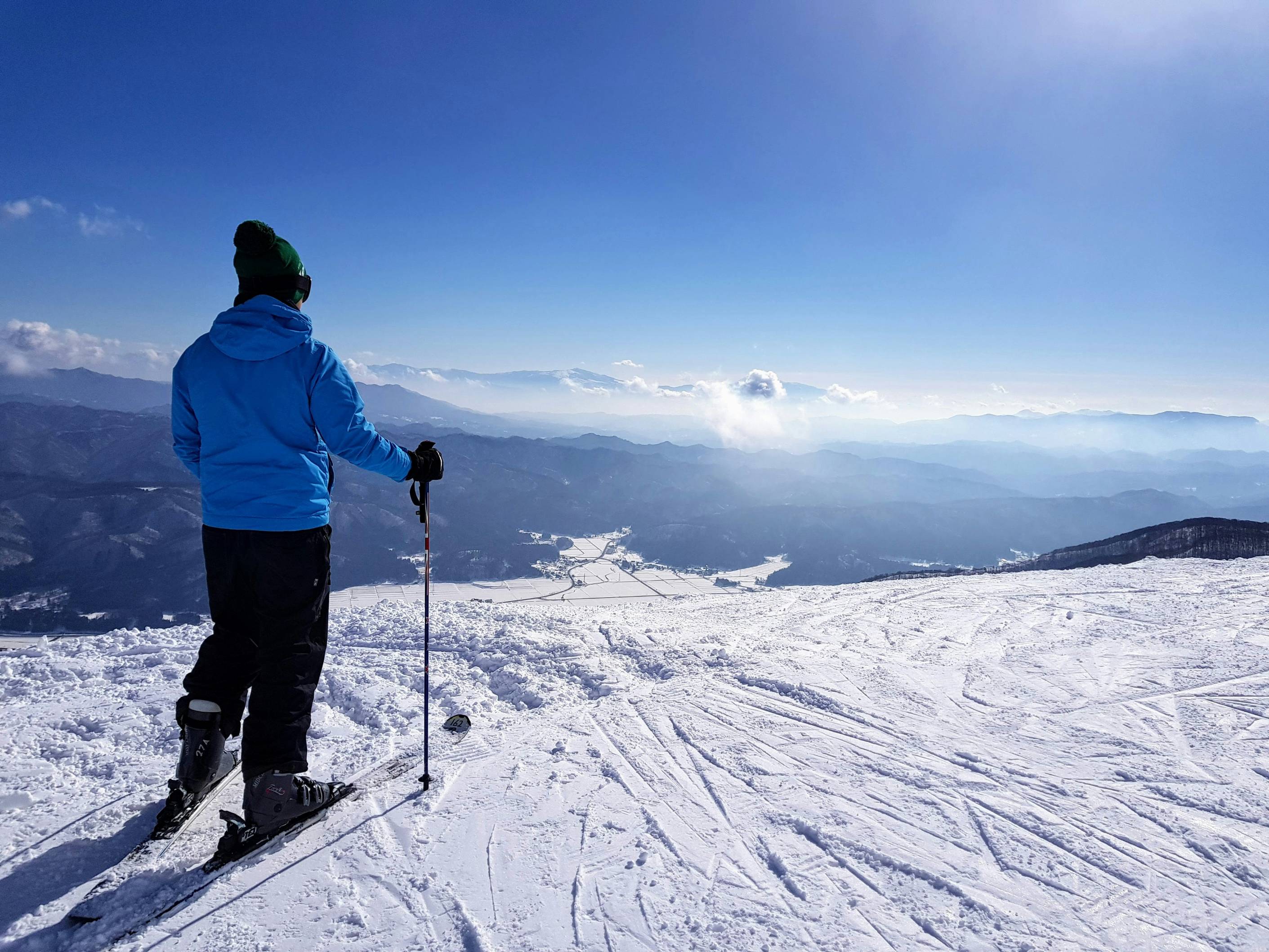 man standing on snow under blue sky